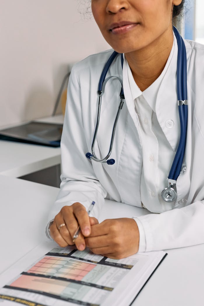 Professional African American female doctor reviewing documents in a clinical setting.